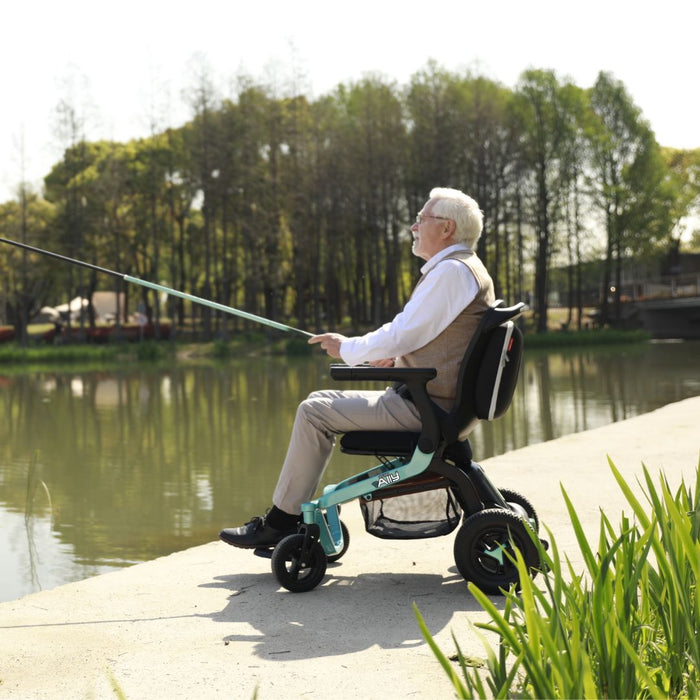Elderly person fishing while using the Folding Ally Power wheelchair GP303